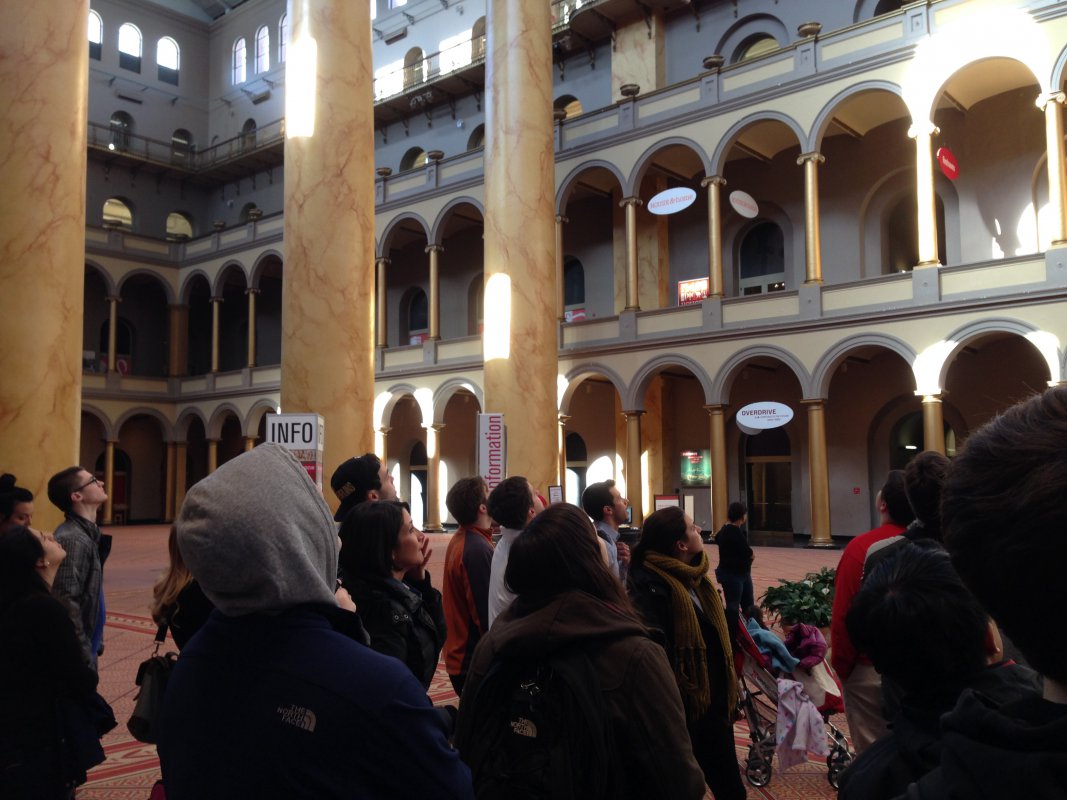 Dr. Mazzenga and her class look up at the classical architecture in the National Building Museum.