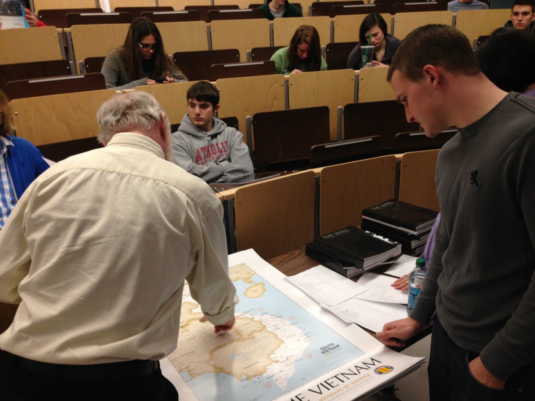 Bill Gray, a Vietnam War veteran, discusses the geography of Vietnam with a CUA student.